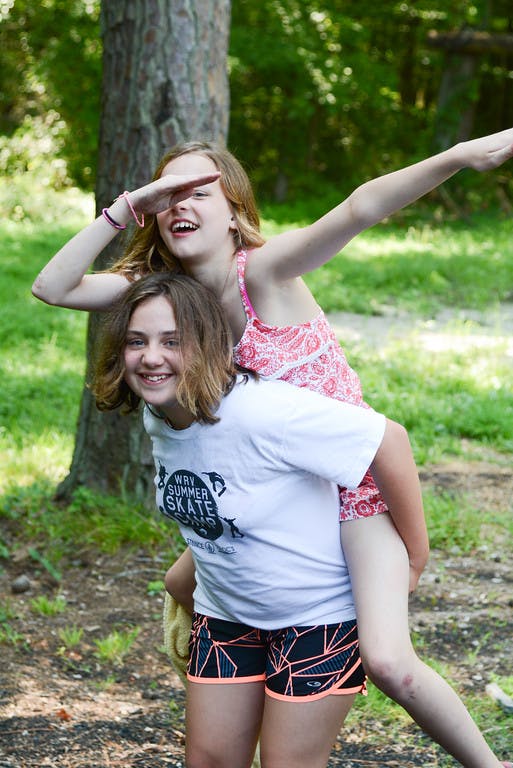 Teen giving a child a piggyback ride outdoors