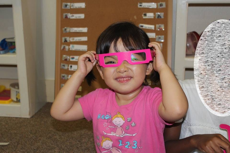 Child wearing pink novelty glasses