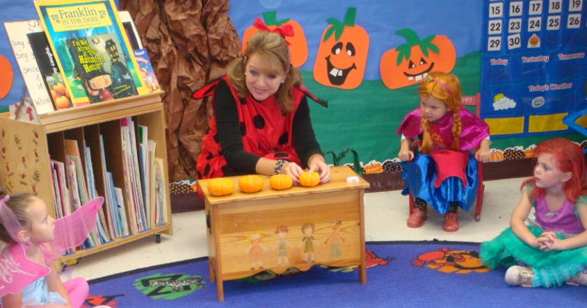 Person in costume with children in costumes in a classroom