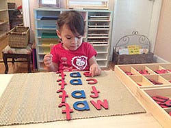Child playing with alphabet letters on a mat