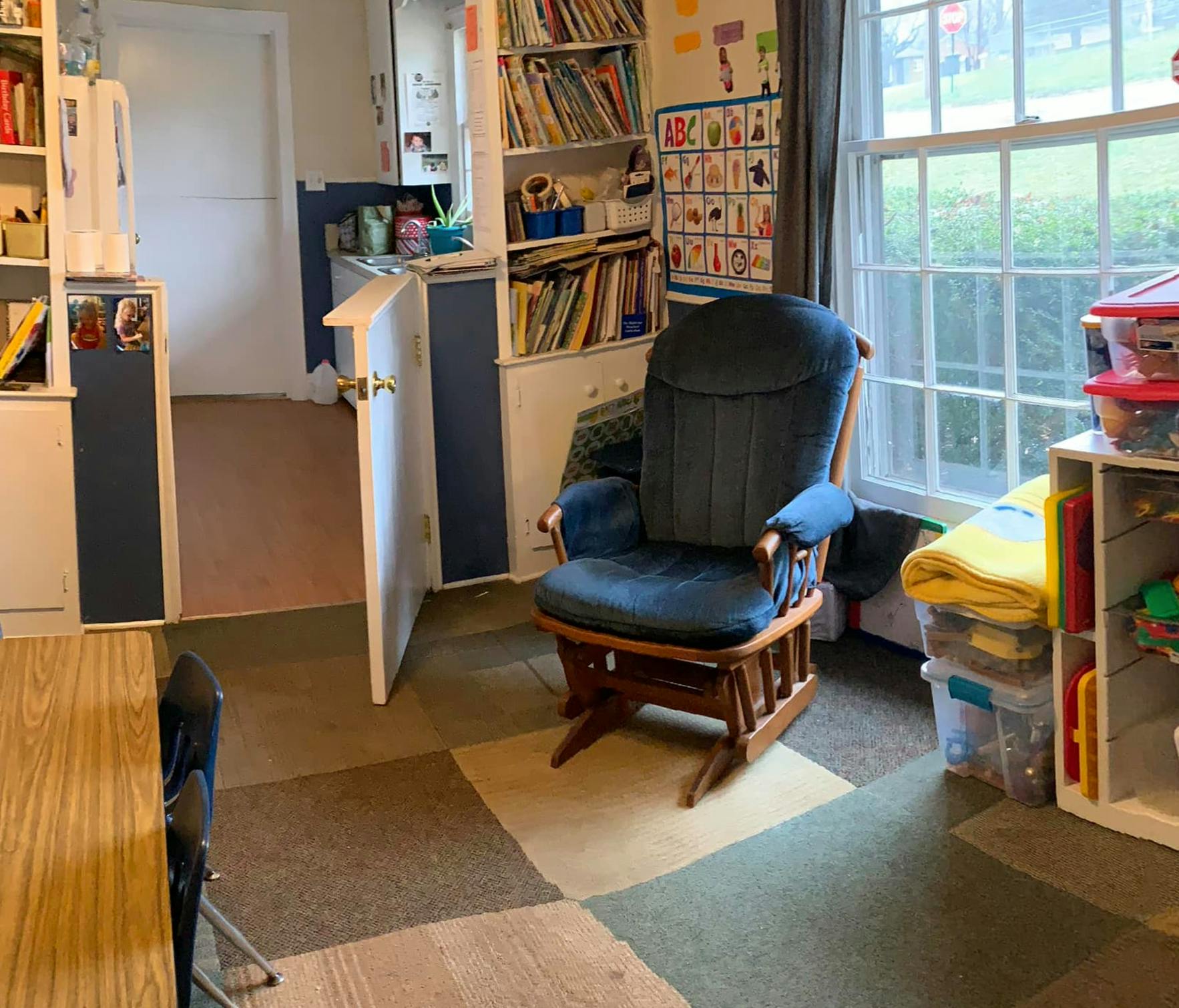 Rocking chair in a room with bookshelves and a window