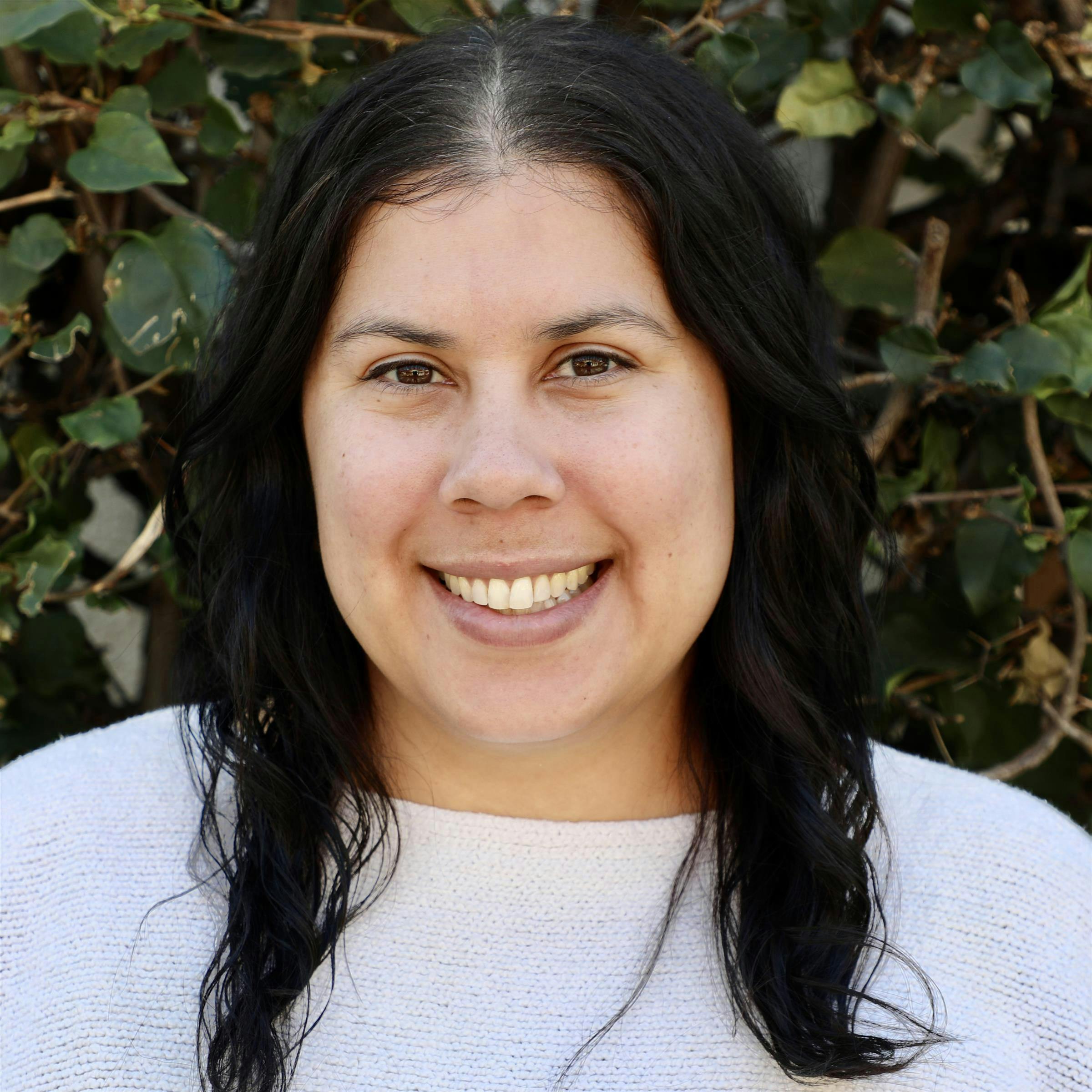 A person with dark hair smiling at the camera