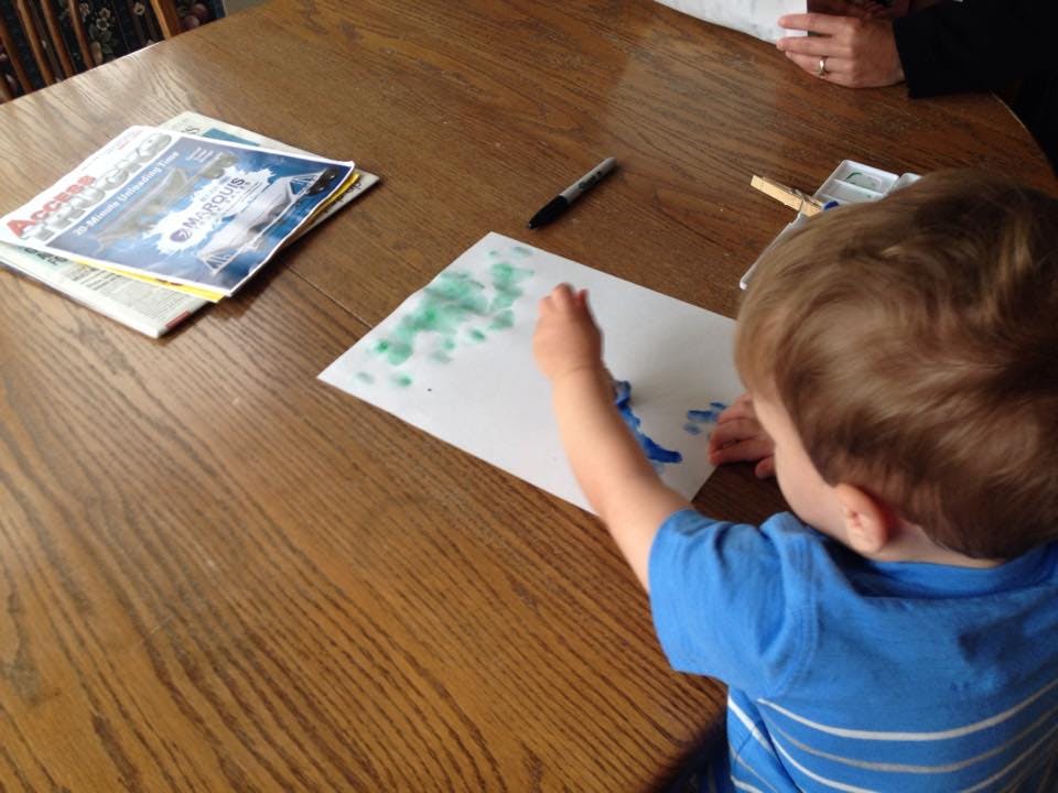 Child painting on paper at a table