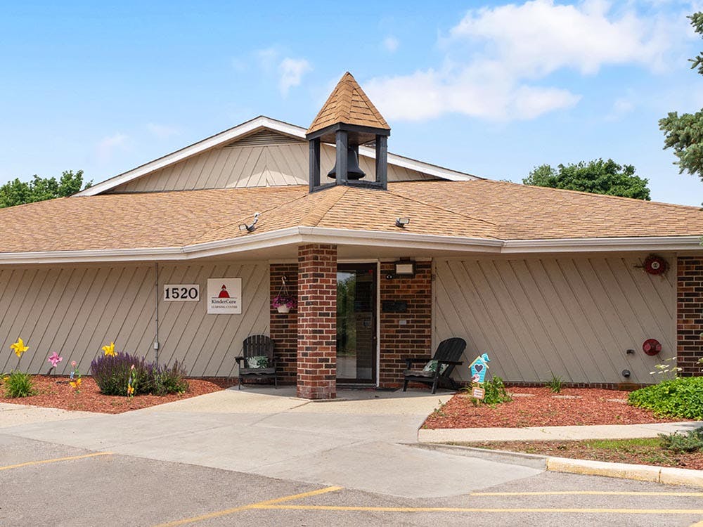 Exterior of a building with a bell tower, brick columns, and a sign for KinderCare
