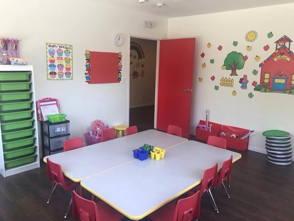 Classroom with a large table and red chairs, colorful wall decorations
