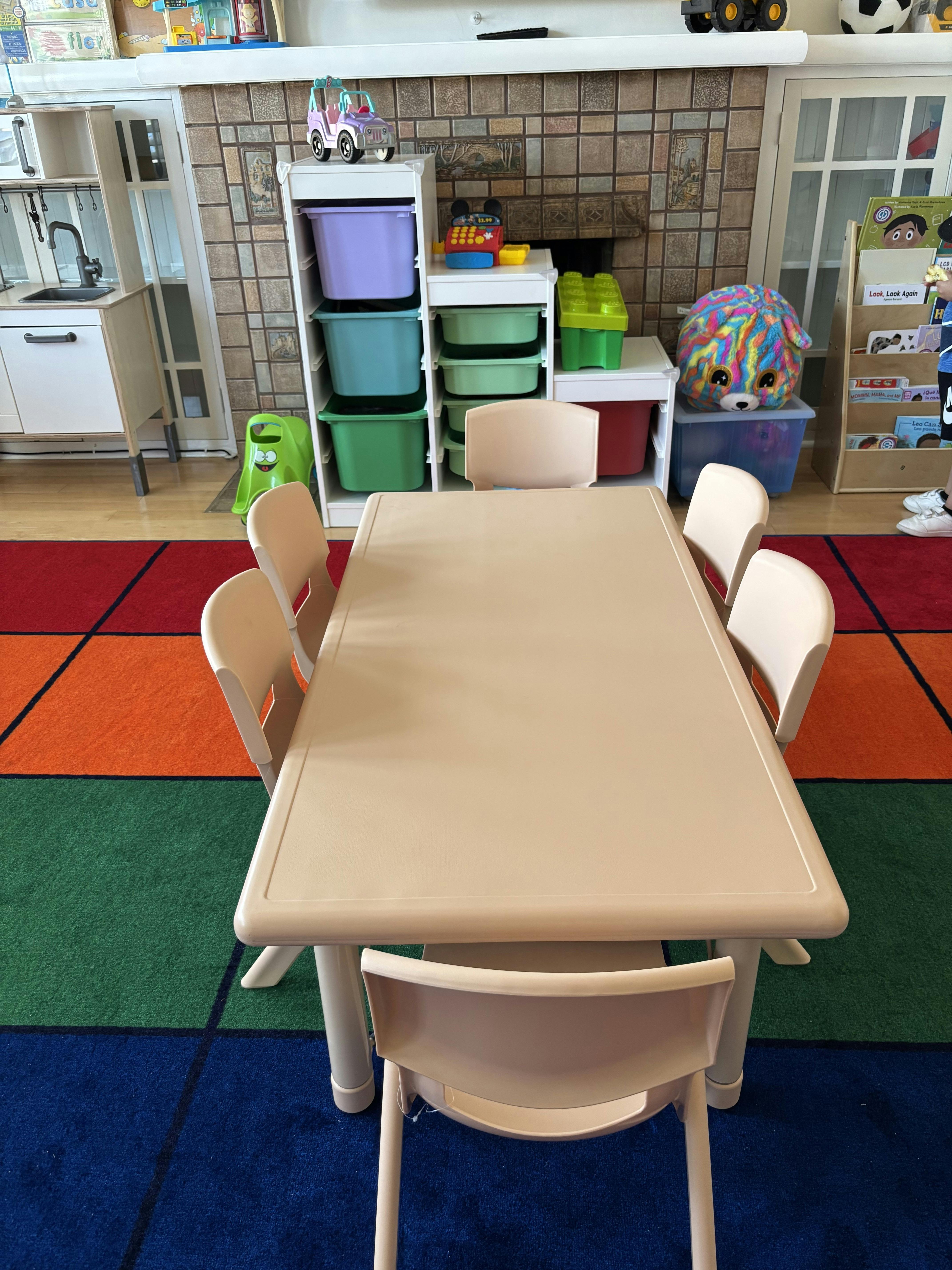 Children's table and chairs on a colorful rug in a classroom