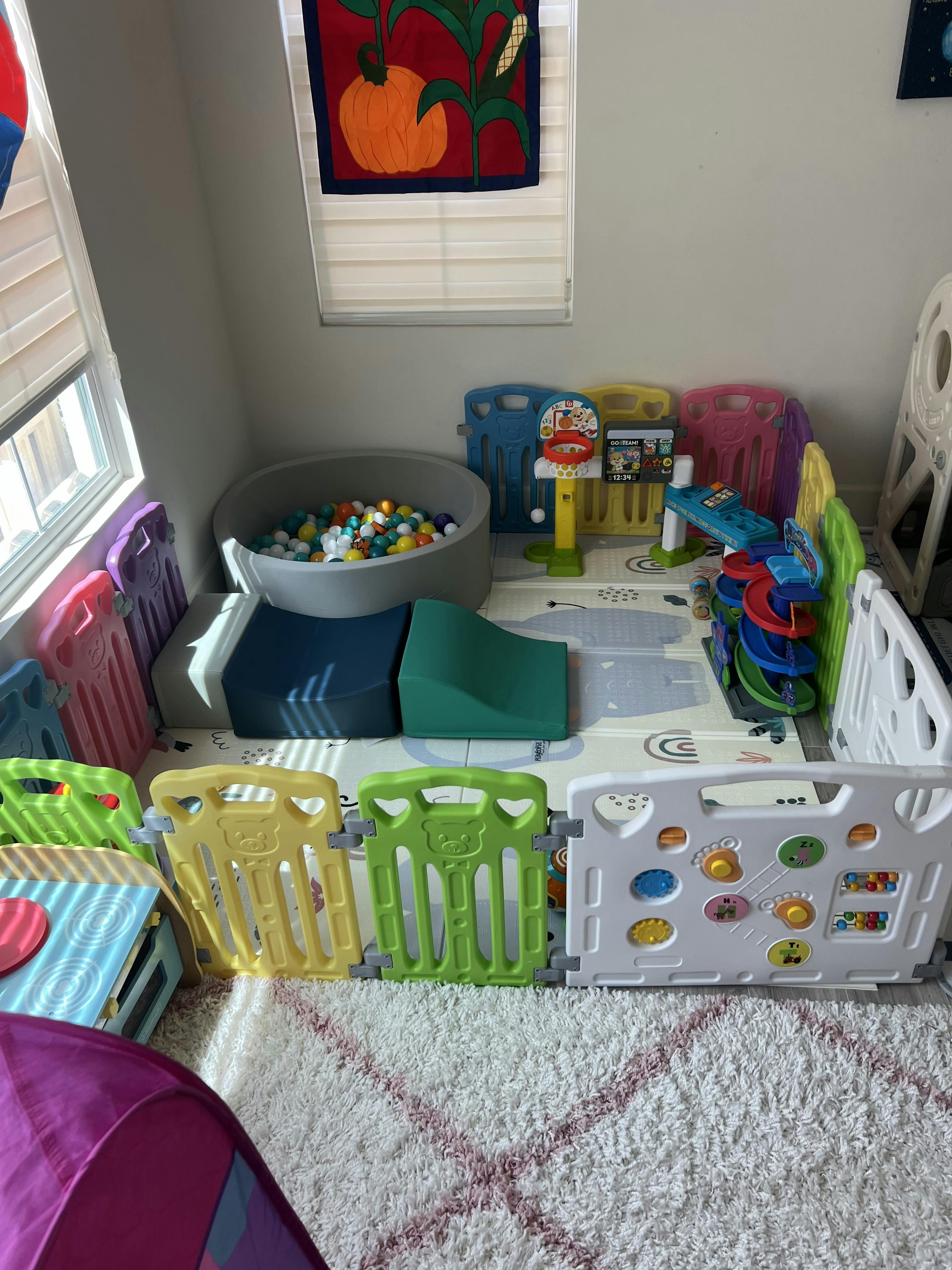 Colorful baby playpen with a ball pit, mini basketball hoop, and slide