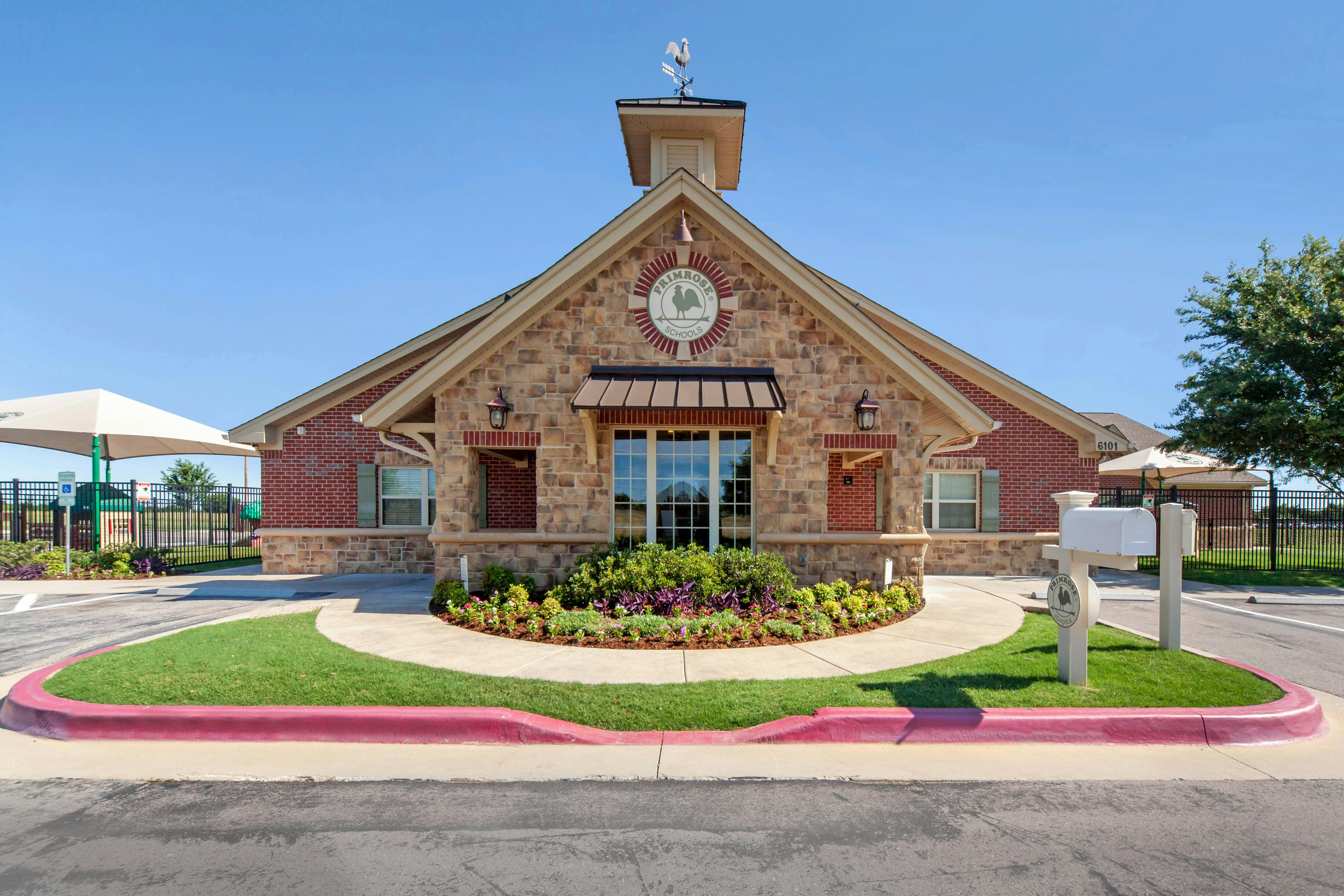 Primrose Schools building with a weathervane and landscaping