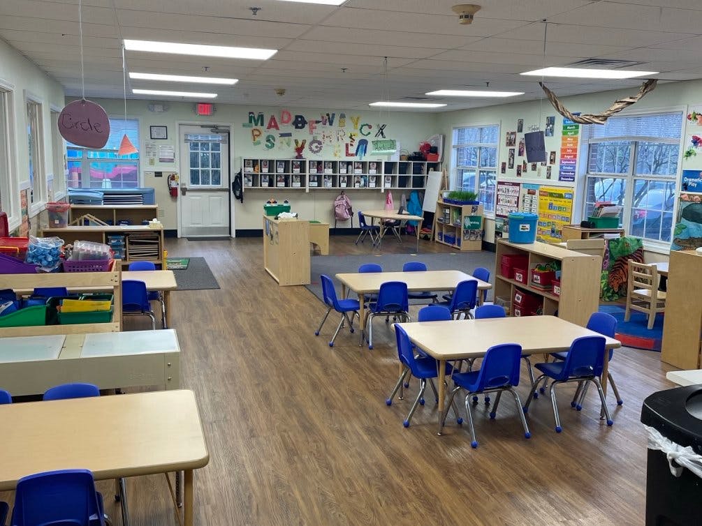 Empty classroom with small tables and blue chairs