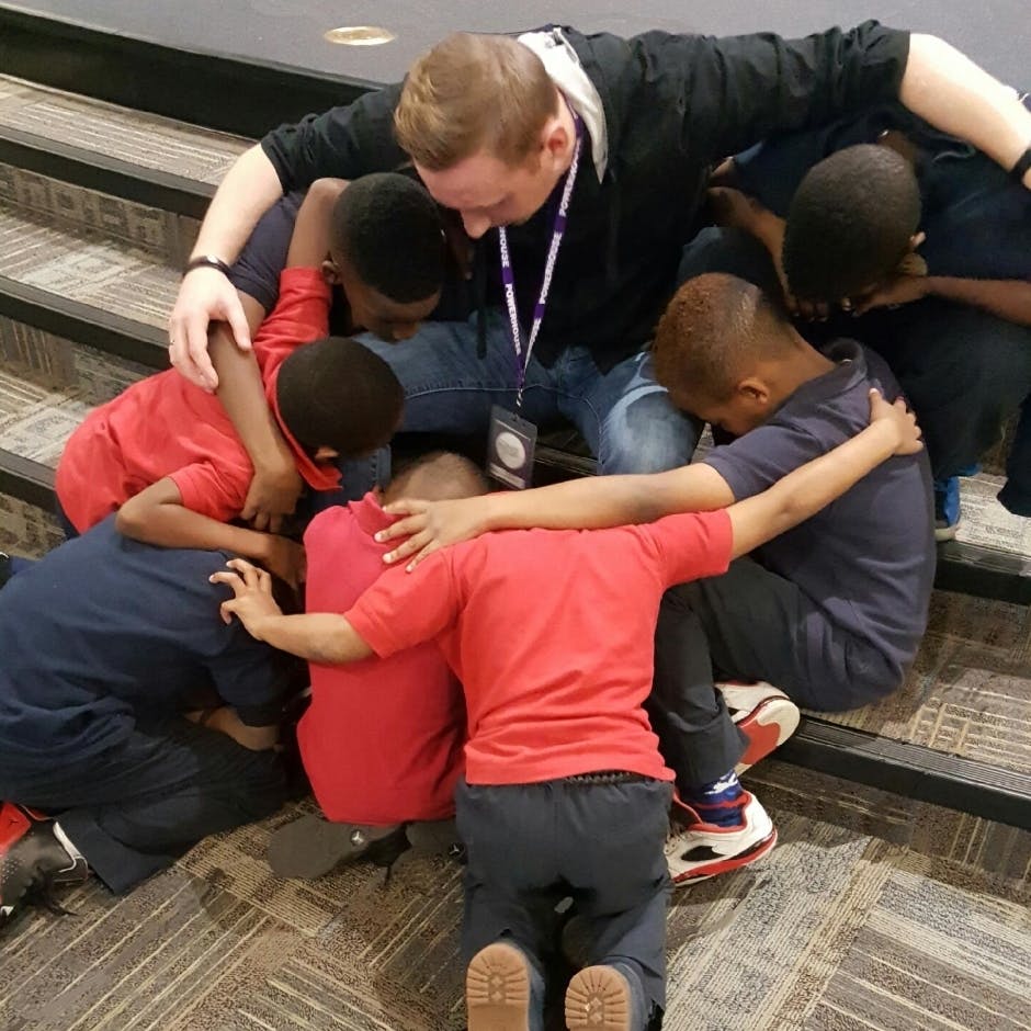 Adult and children kneeling in a group