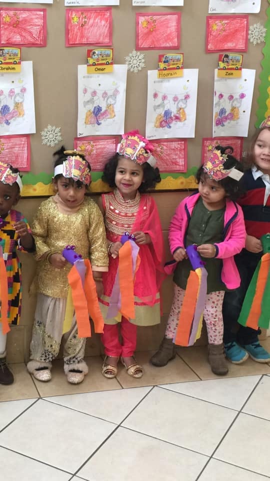 Children in festive headwear holding colorful streamers