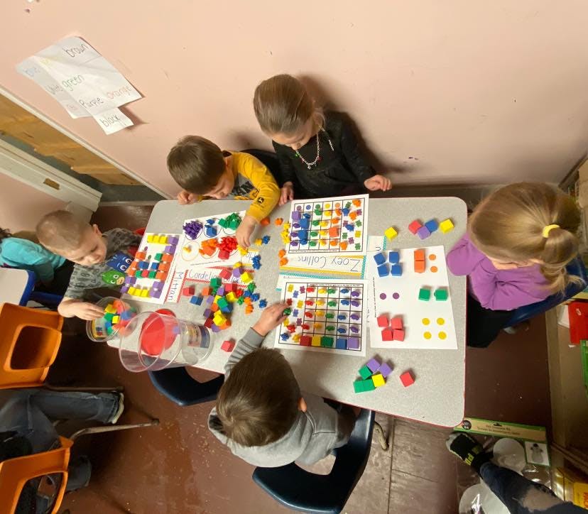 Children playing with colorful blocks and learning materials at a table