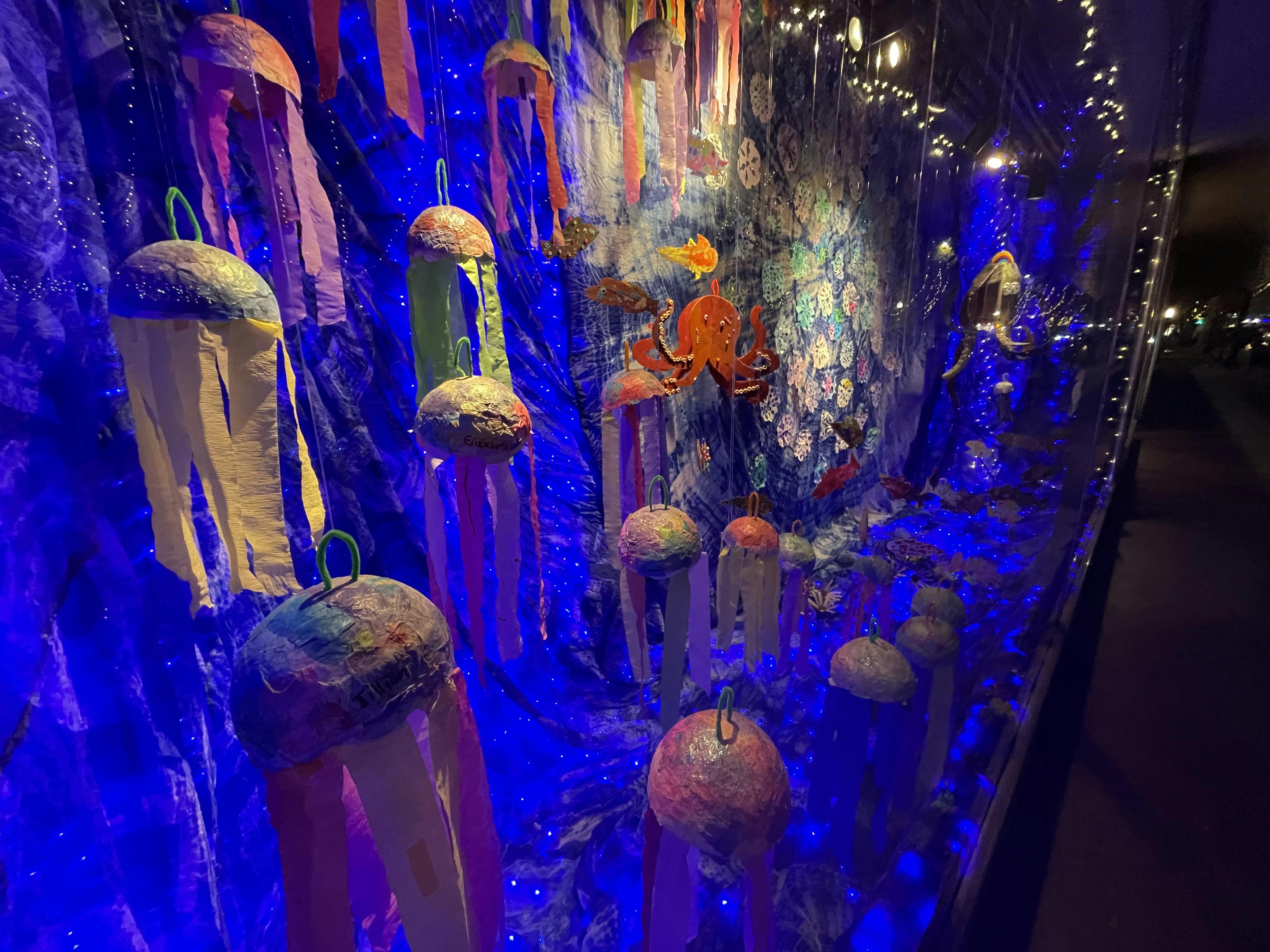 Decorative jellyfish-like lanterns hanging in a blue-lit display