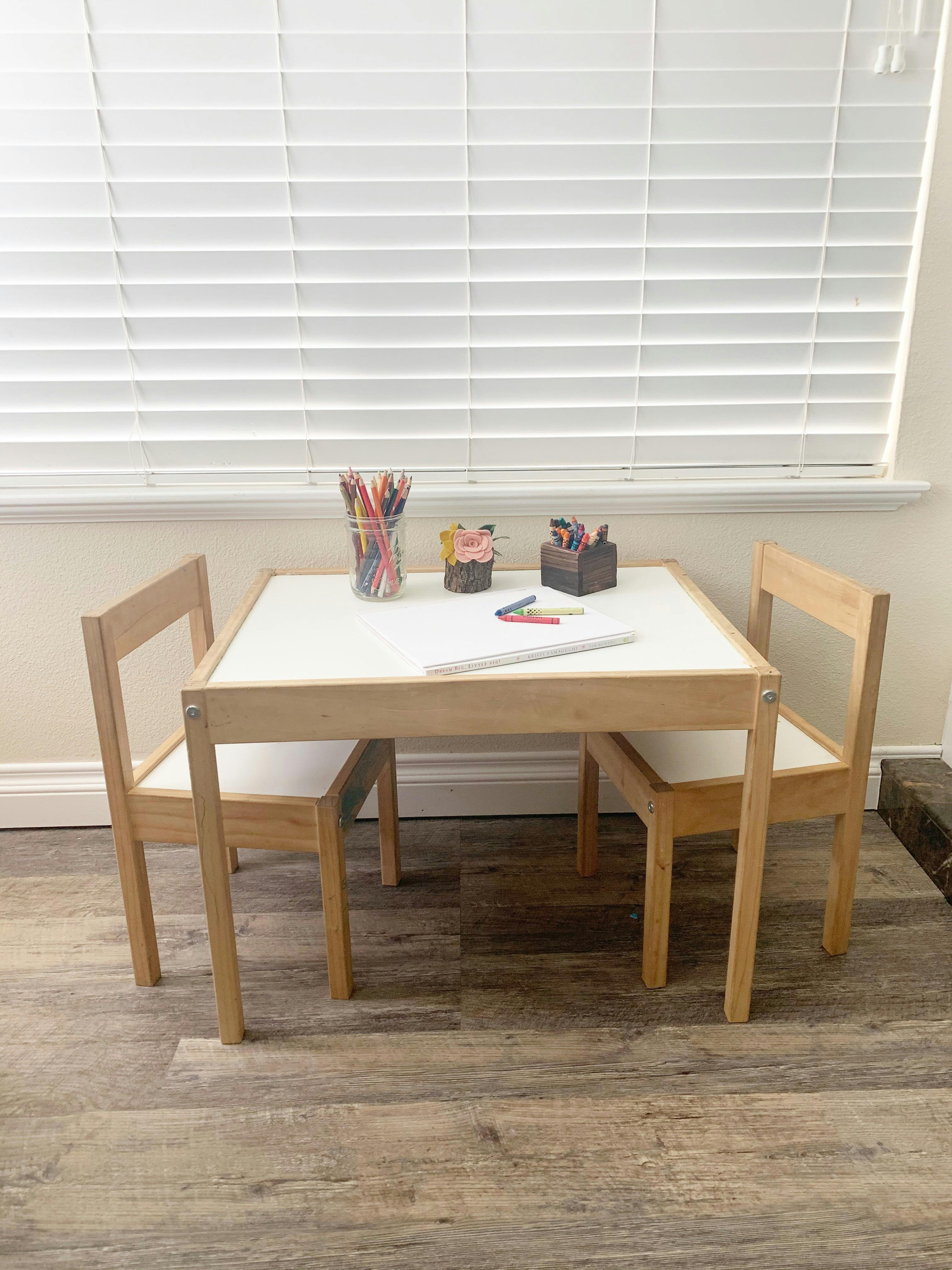 Child's table and two chairs with art supplies