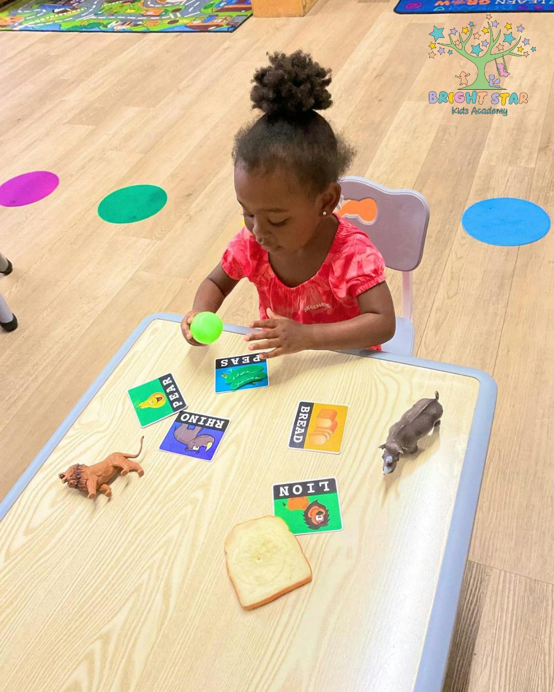 Child playing with cards and toys at a table