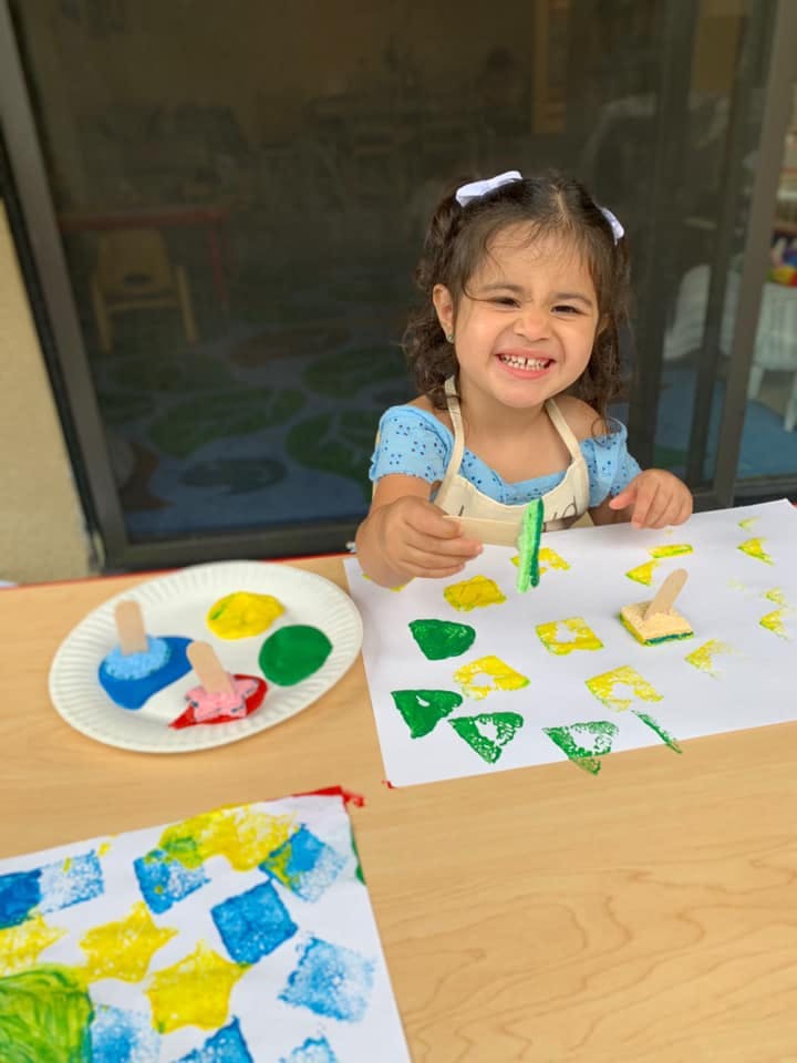 Child painting with sponges and paint on paper