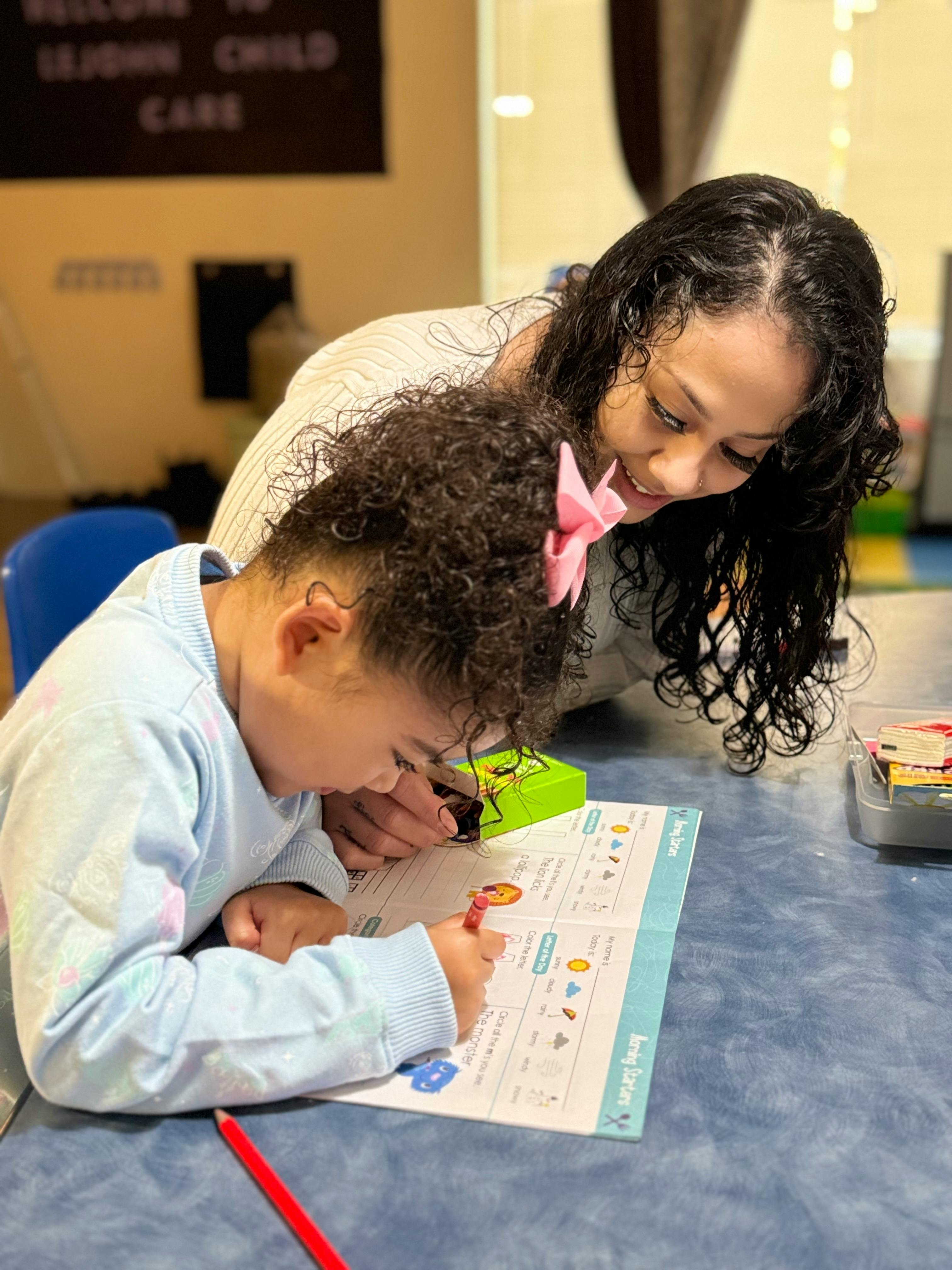 Adult and child looking at a workbook on a table