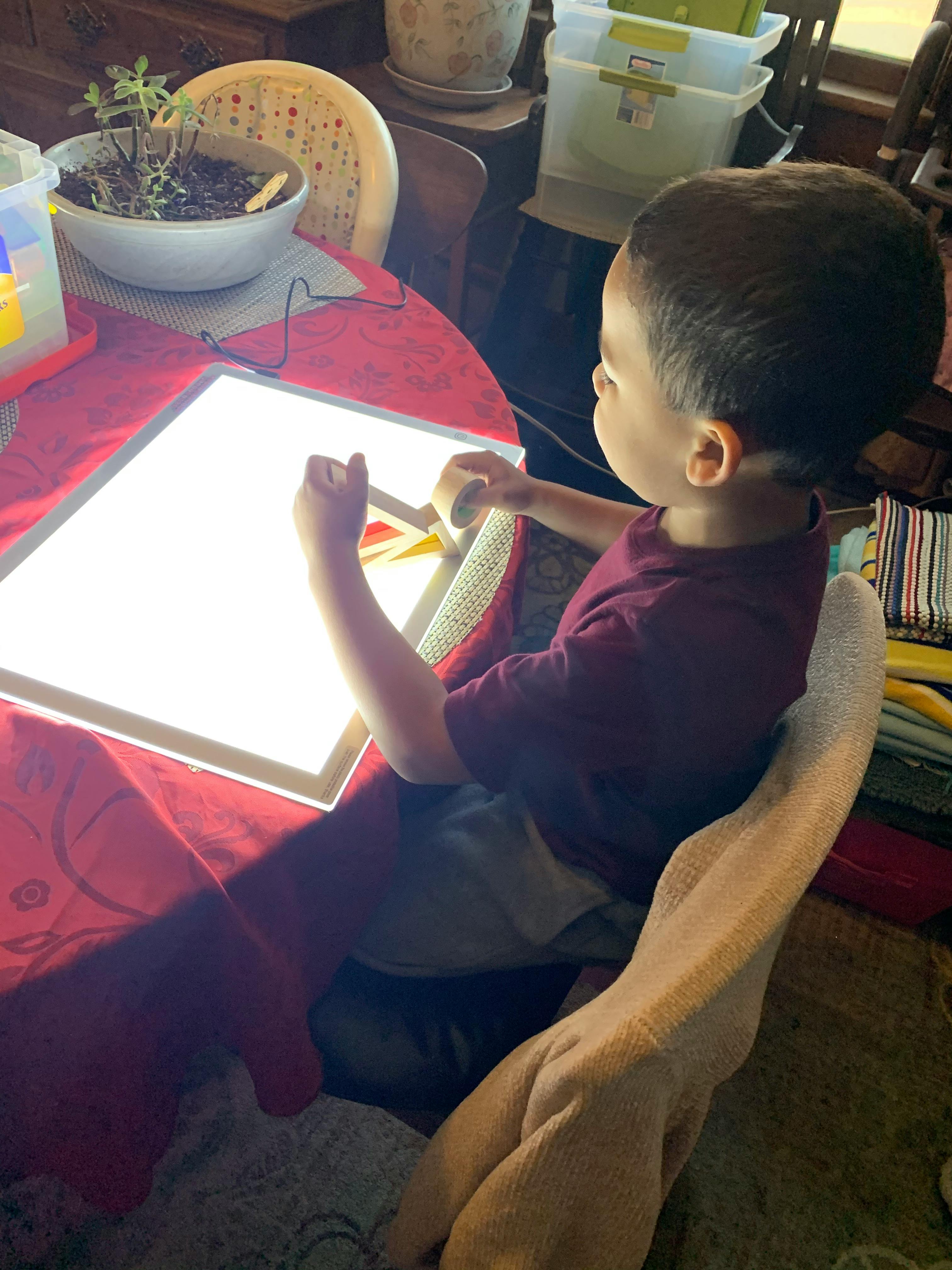 Child playing with blocks on a light-up board