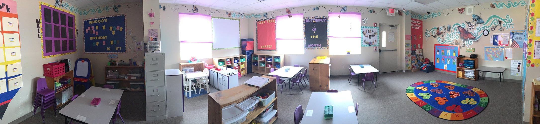 Empty classroom with tables, chairs, and colorful decorations