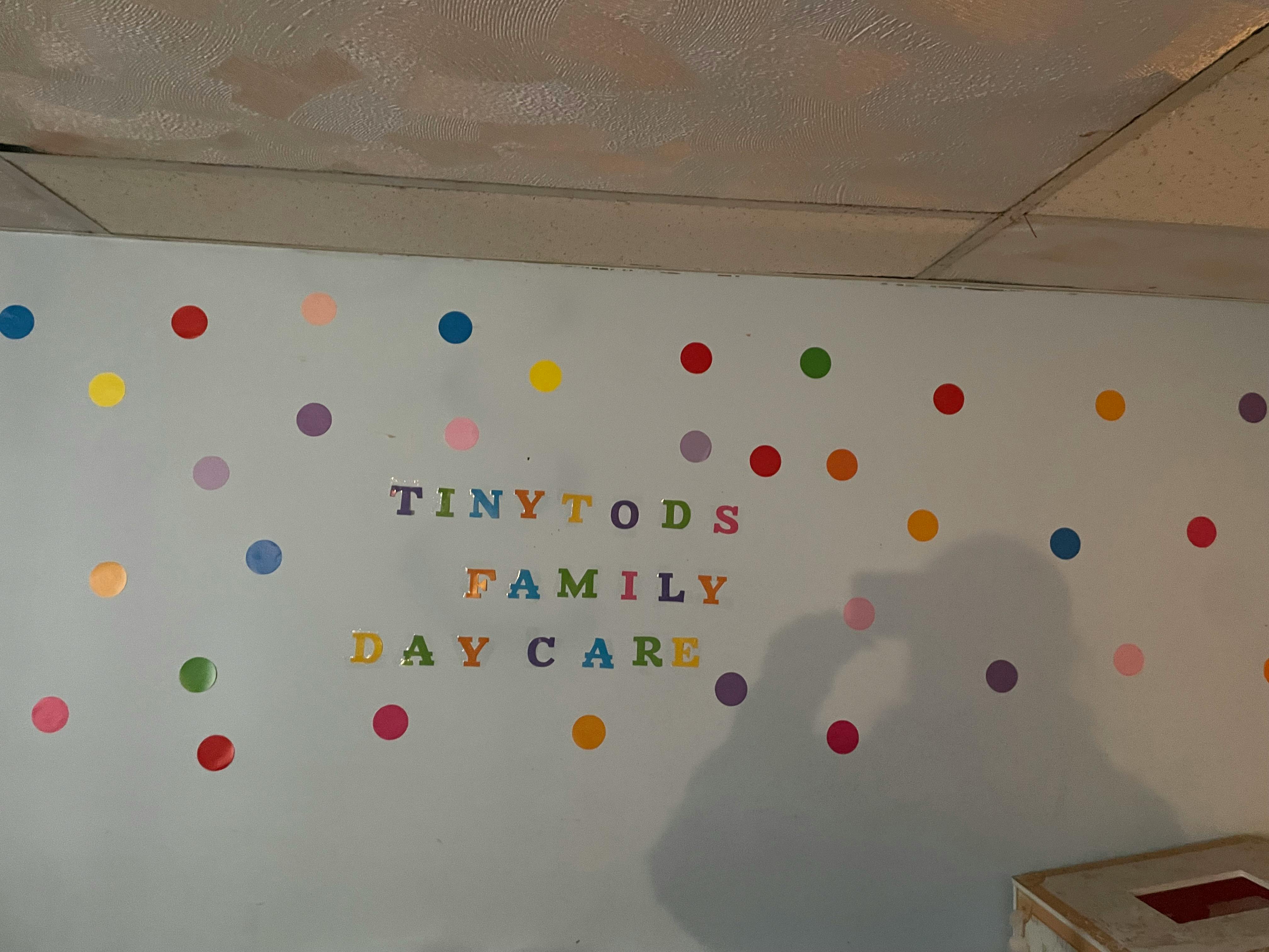 Wall with colorful polka dots and "TINY TODS FAMILY DAY CARE" text