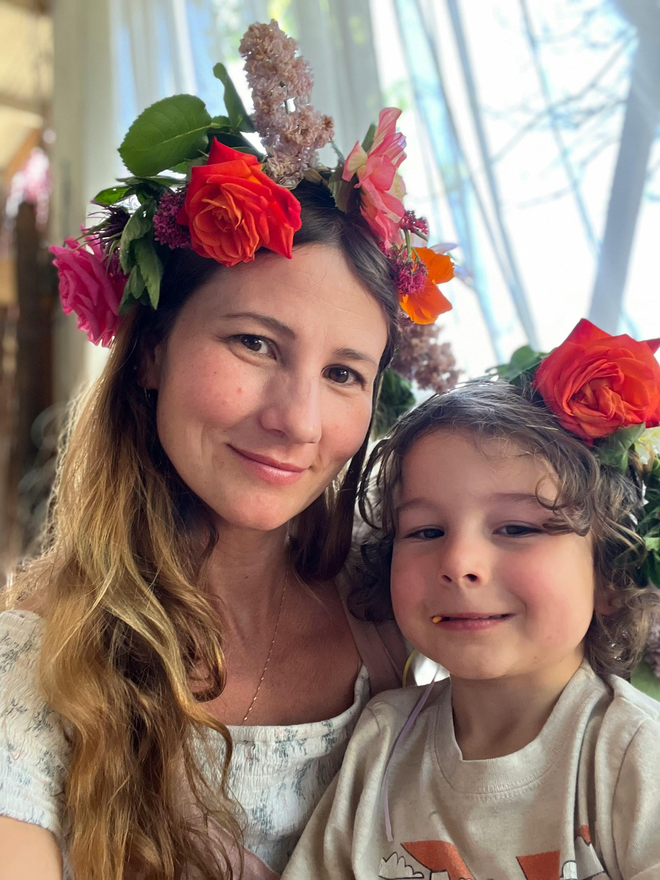 Person and child wearing flower crowns