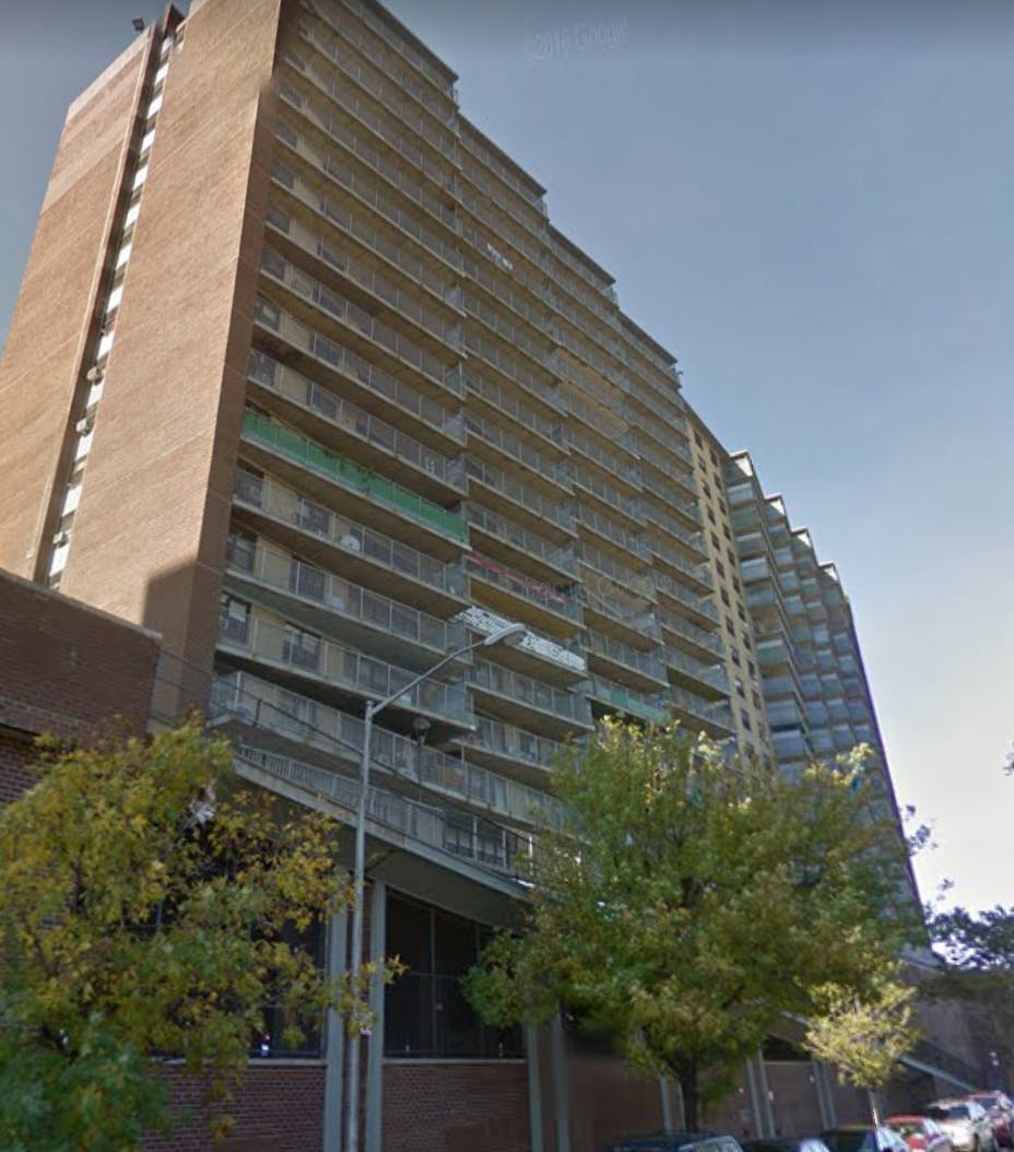 Tall brick apartment building with many balconies