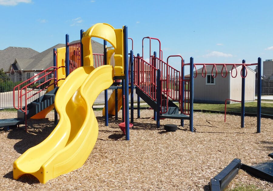 Playground with yellow slides, red stairs, and monkey bars