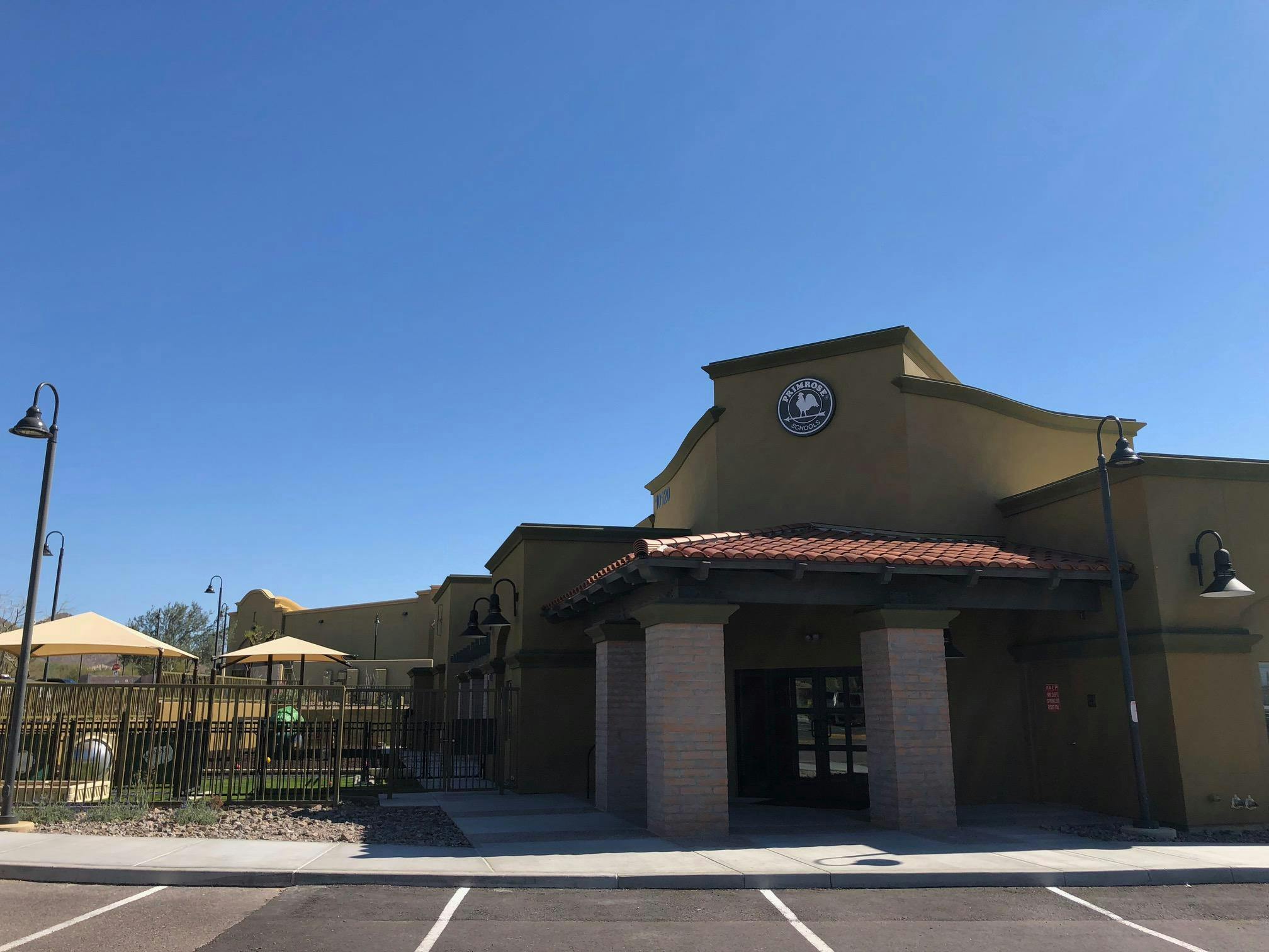 Building exterior with a covered entrance and a parking lot in front