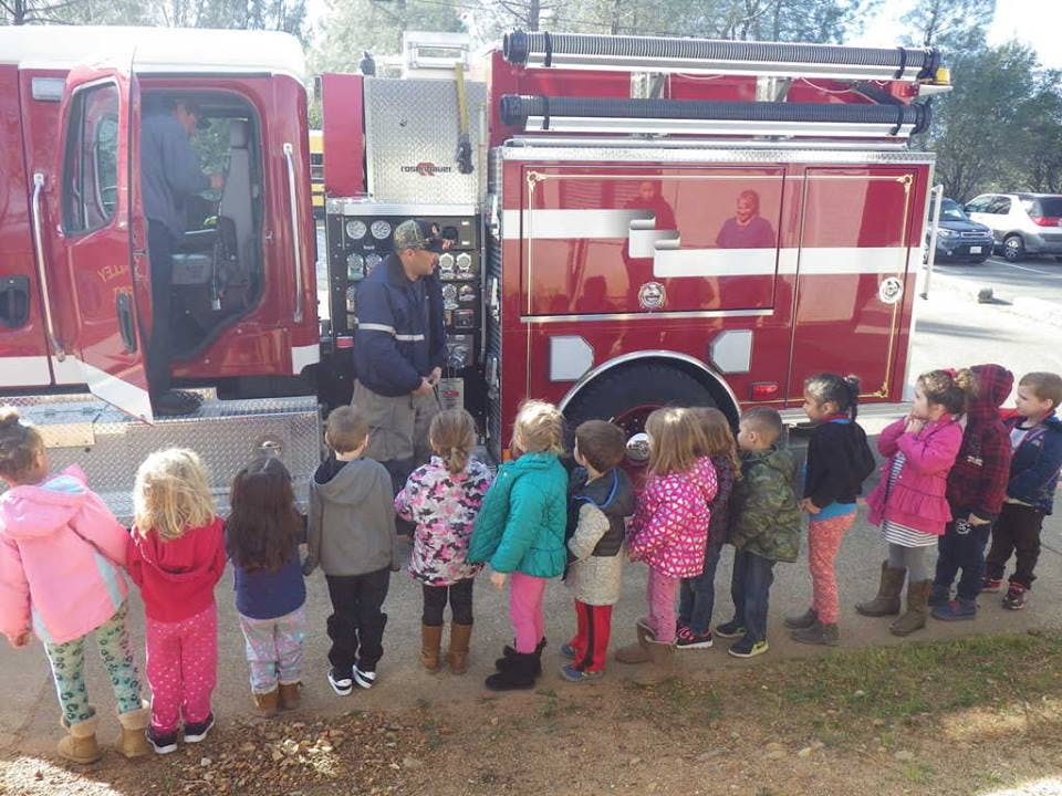 Person showing children a fire truck