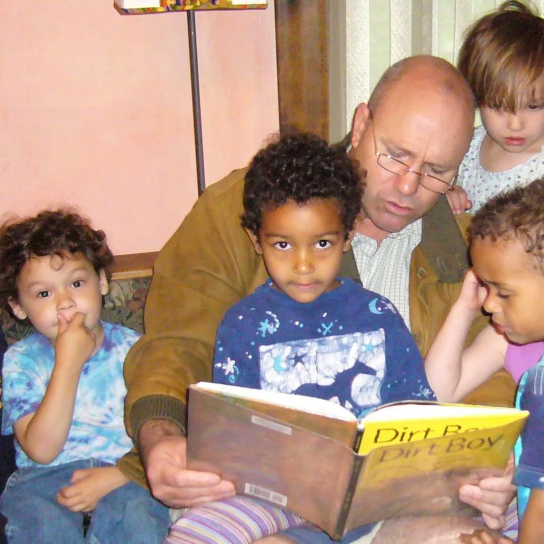 Person reading a book to multiple children