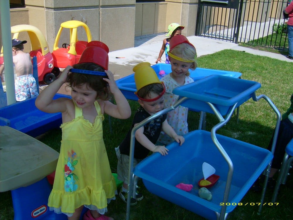 Children playing with water tables outdoors