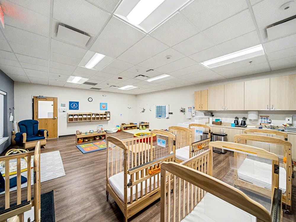 Baby room with multiple cribs and a changing station
