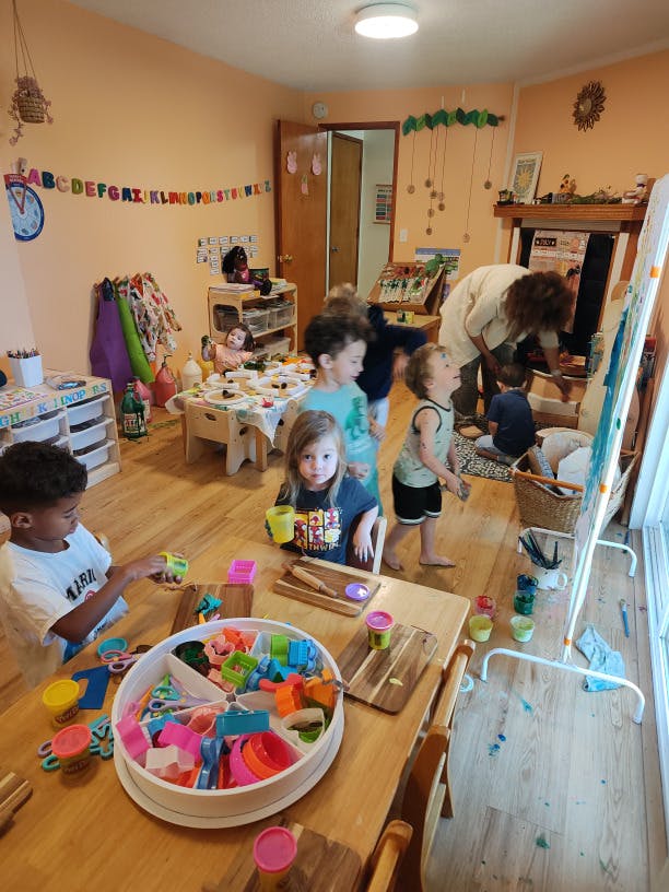 Group of children playing with art supplies and playdough in a classroom