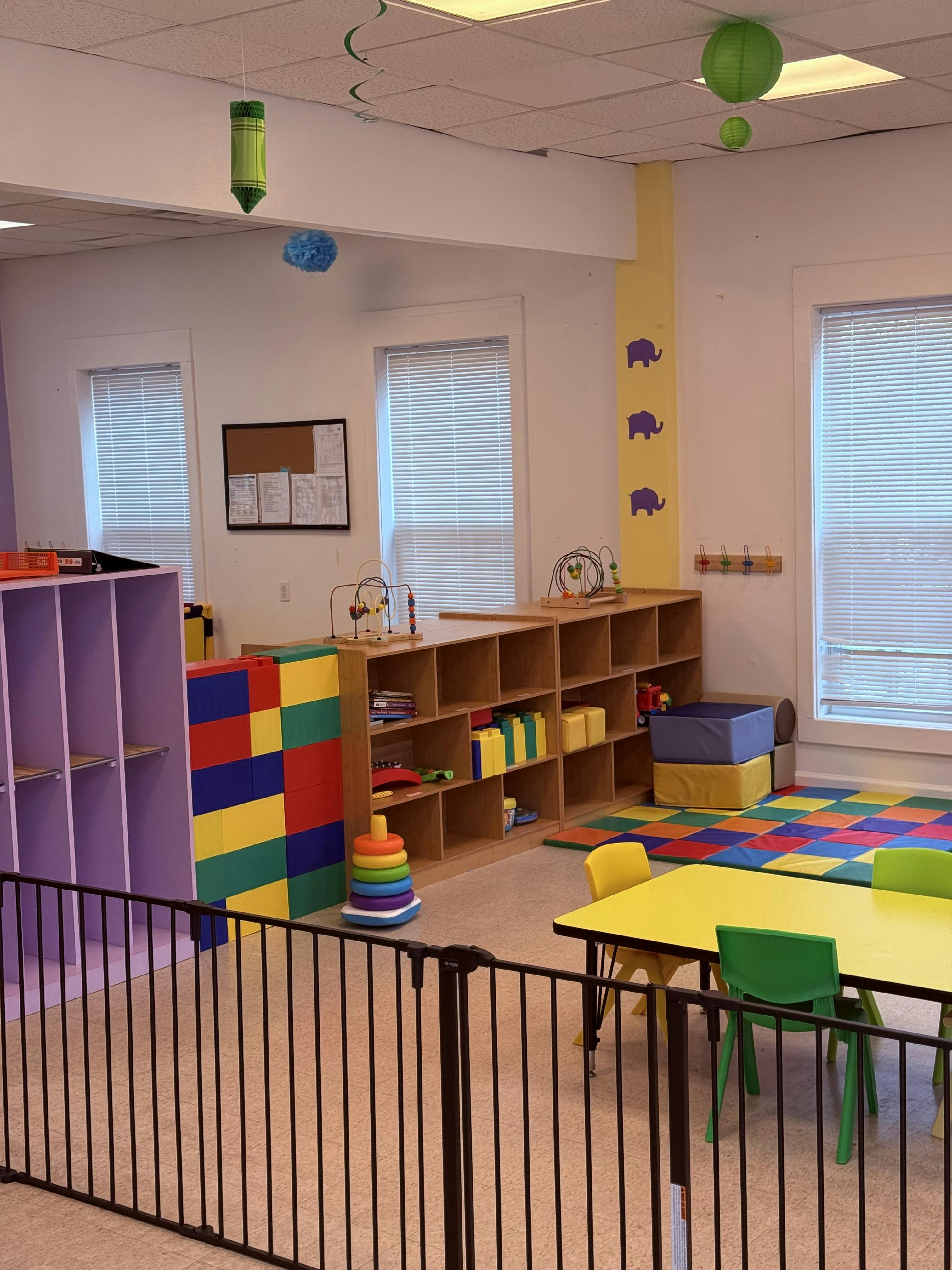 Playroom with colorful blocks, shelves, and small tables
