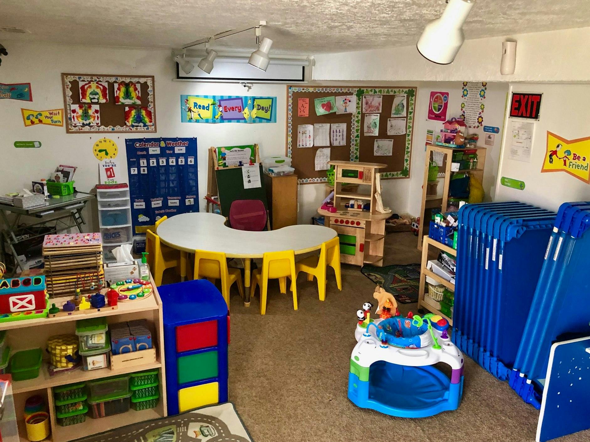 A classroom with a crescent-shaped table and yellow chairs