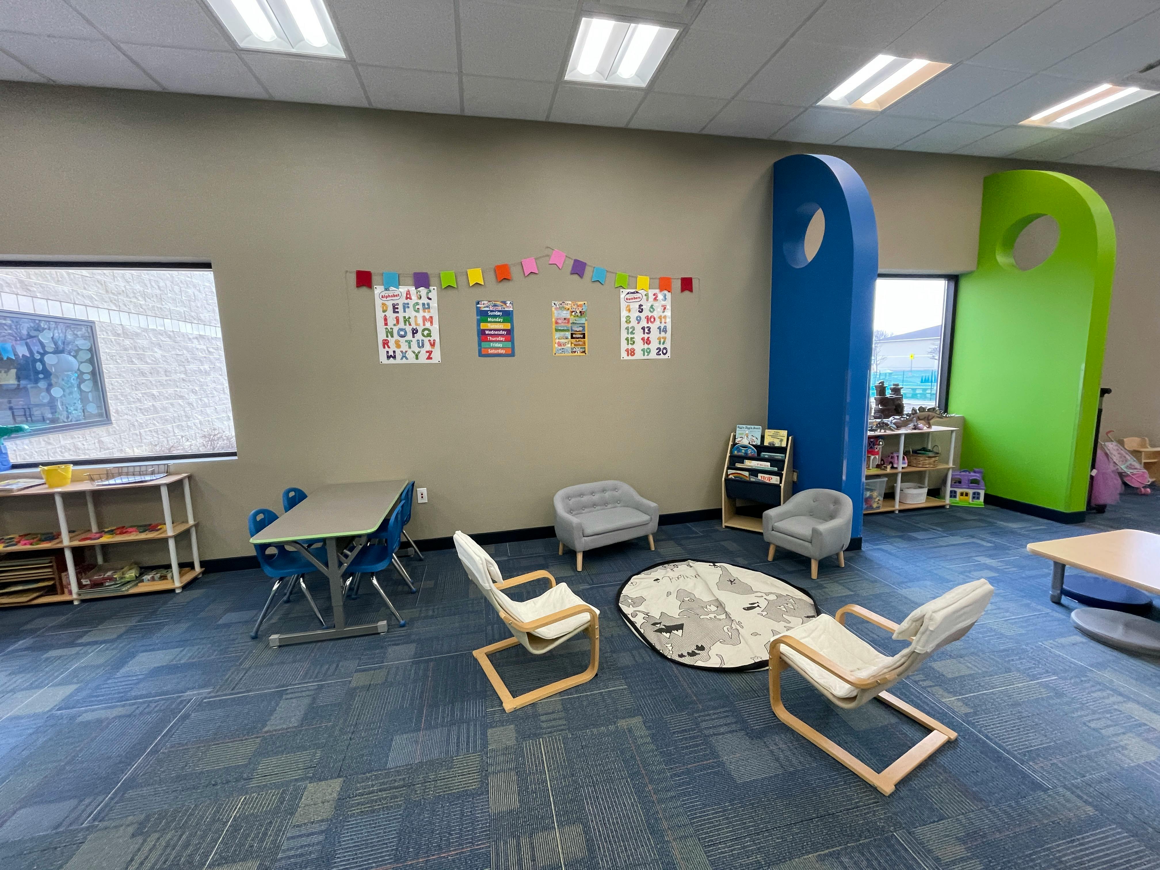Classroom with small tables, chairs, and colorful wall decorations