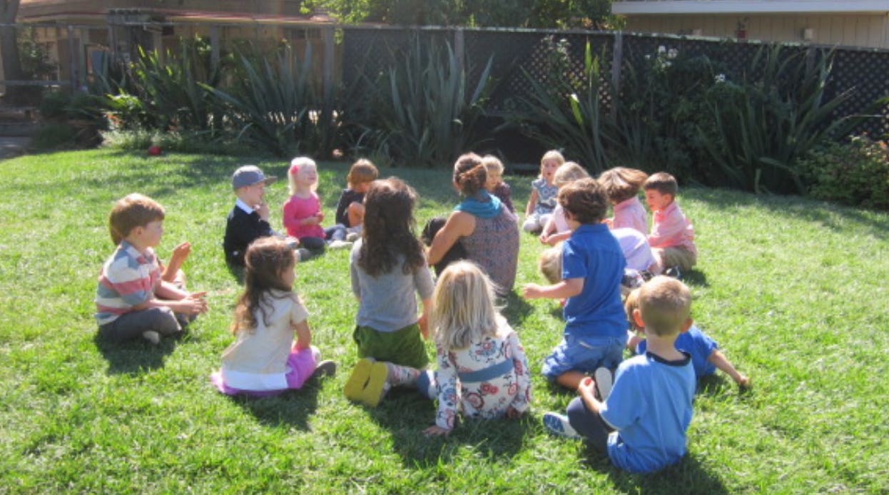 Children sitting in a circle on grass