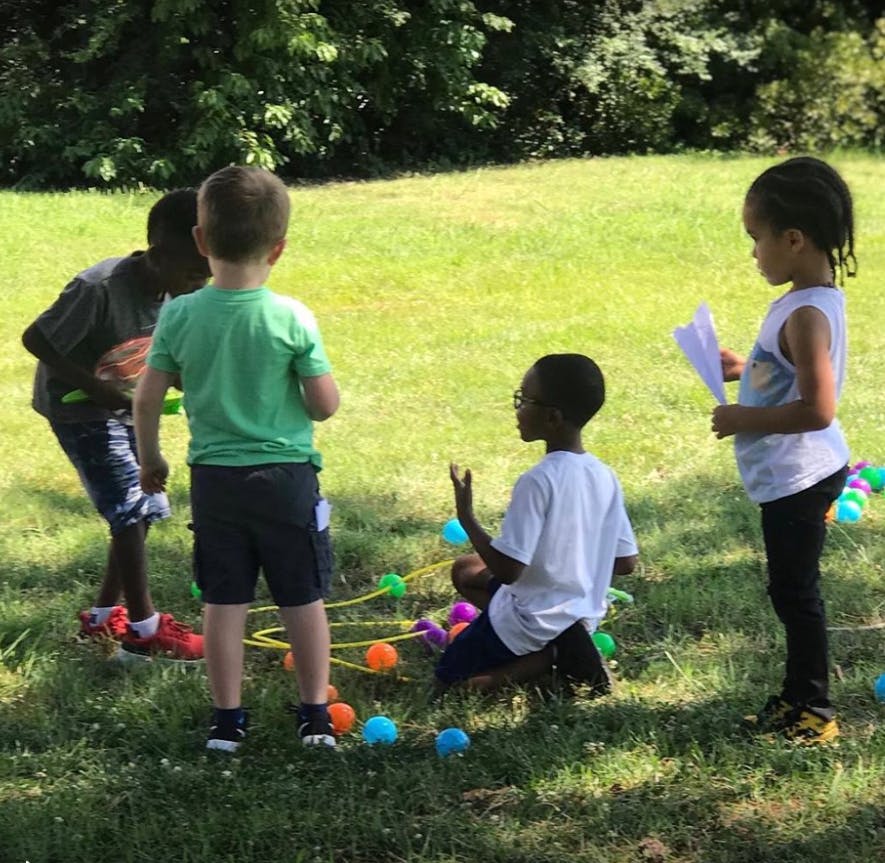 Children playing with colorful balls and string on grass
