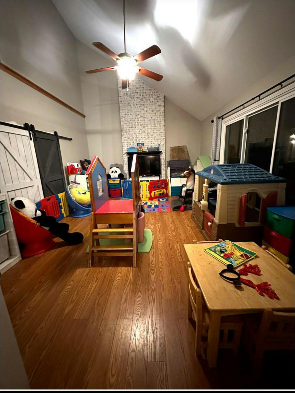 Playroom with various toys, a small table and chairs, and a playhouse
