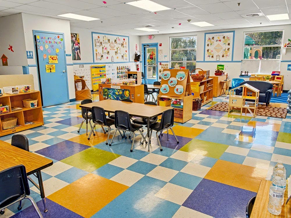 Colorful classroom with small tables, chairs, and shelves