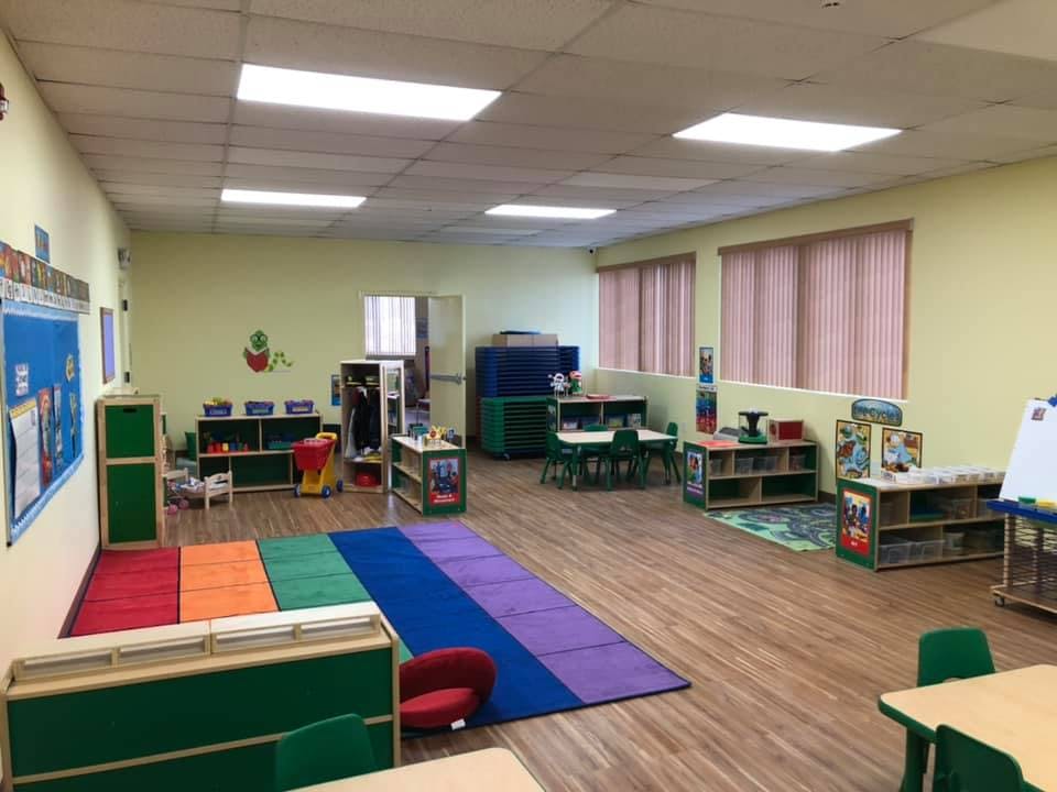 Empty classroom with colorful rugs and small tables