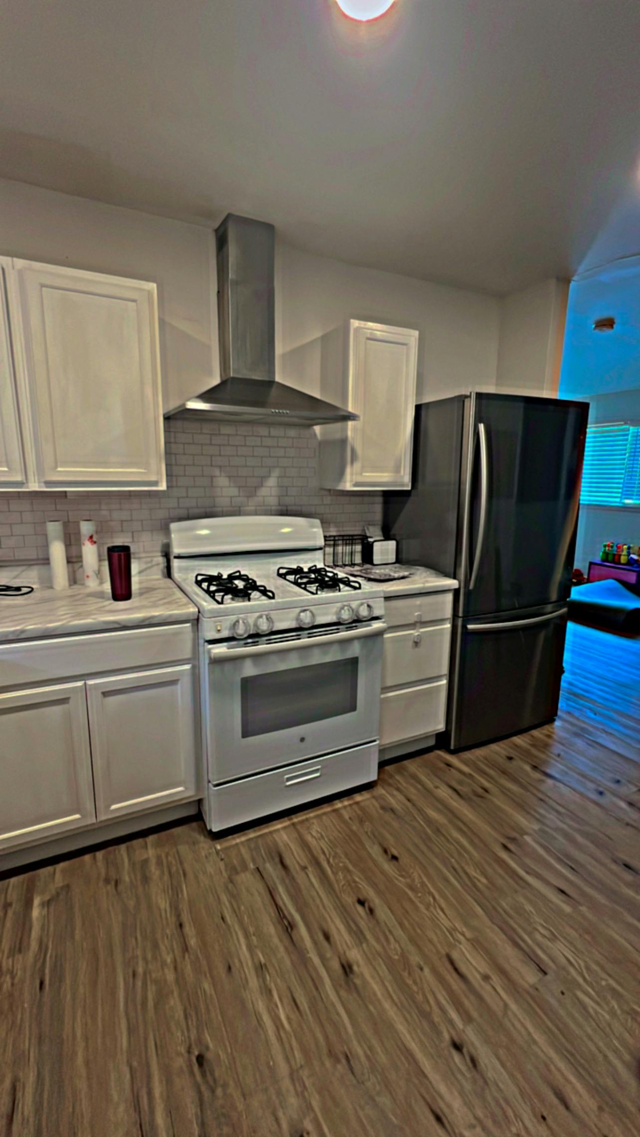 Kitchen with white cabinets, white stove, and black refrigerator