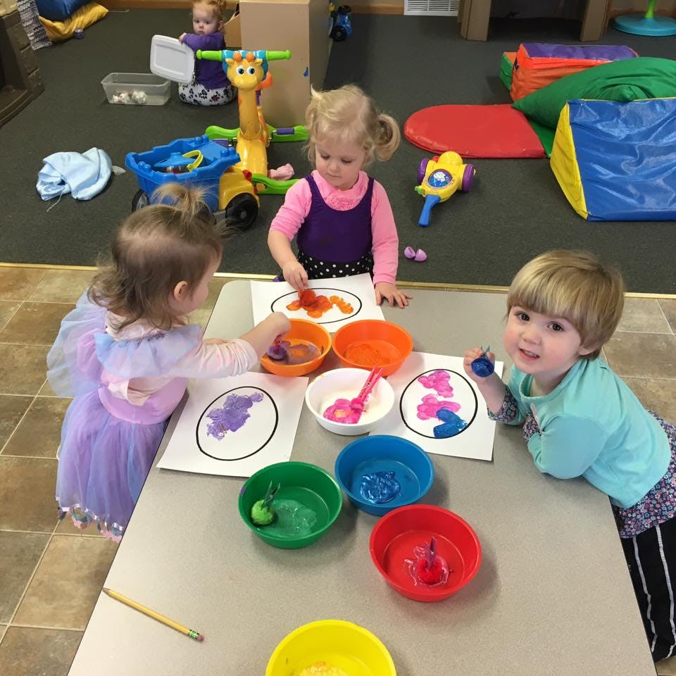 Three children painting at a table