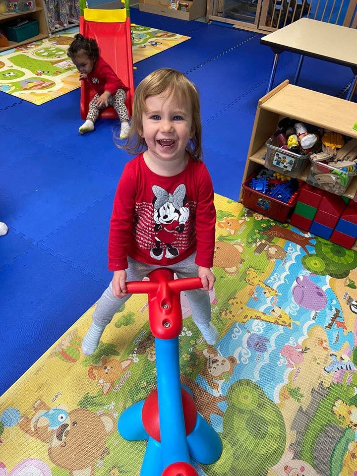 Child on a toy pogo stick in a playroom