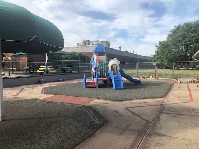 Playground with a colorful climbing structure, slides, and tricycles
