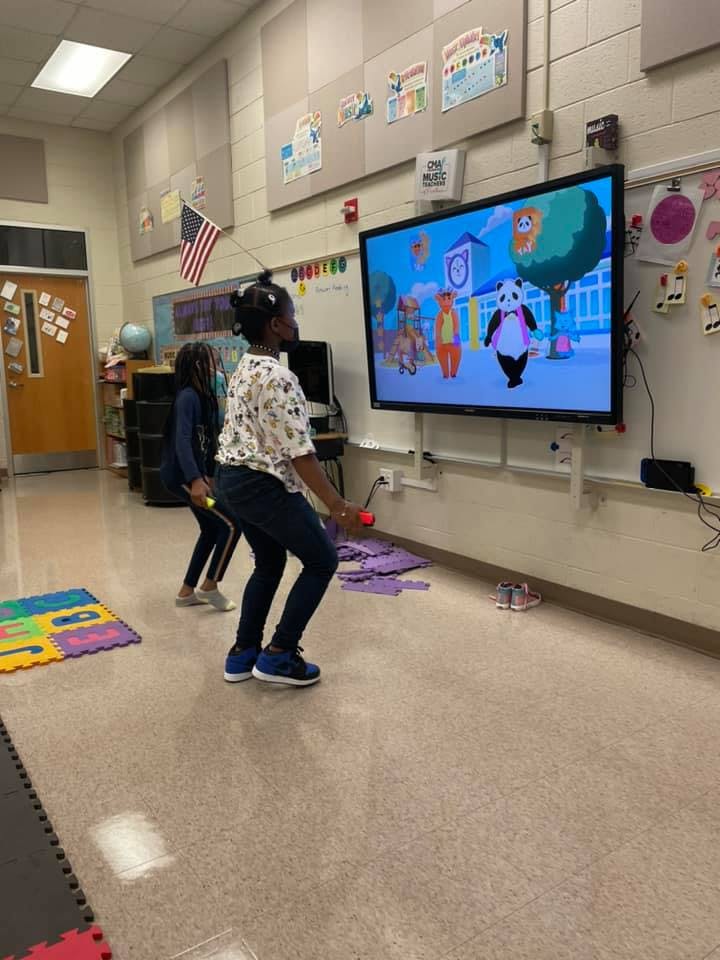 Two children playing a video game in a classroom