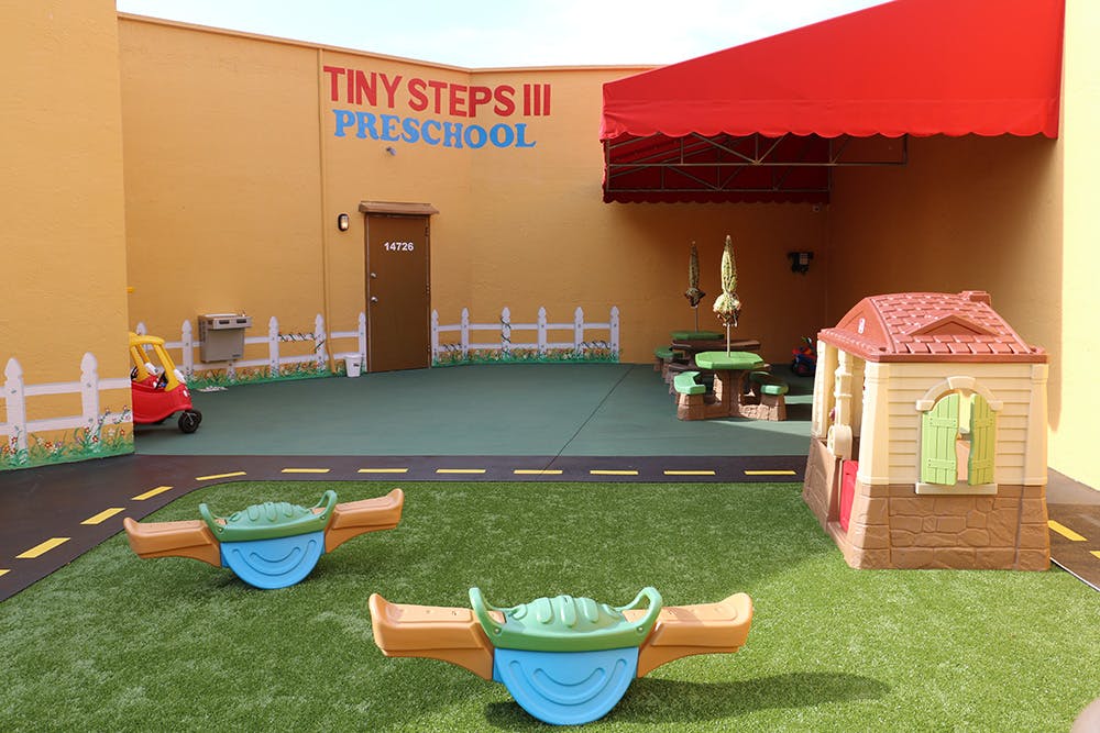 Preschool playground with Tiny Steps III Preschool sign, playhouse, and seesaws