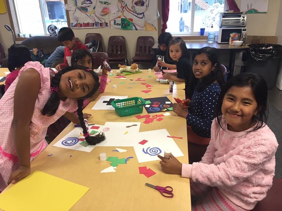 Children sitting at a table doing crafts
