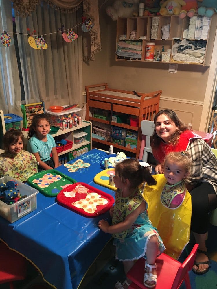 Adult and children at a table with craft supplies