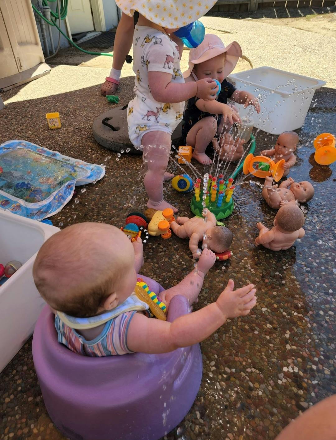 Children playing with water and toys outdoors